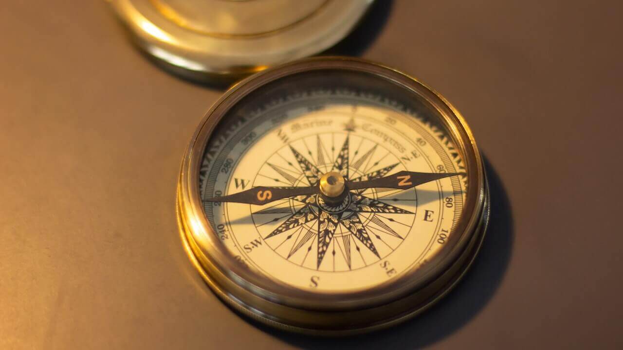 An image of an antique compass, showcasing a vintage design with a weathered exterior.